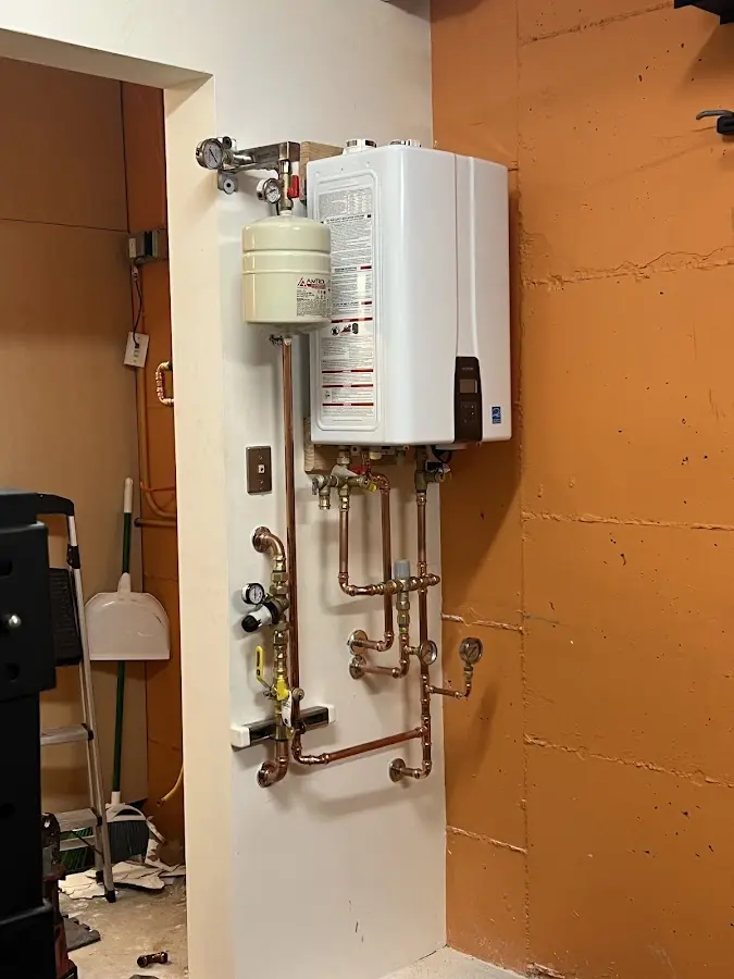 Plumbing technician inspecting water heater connections in Live Oak